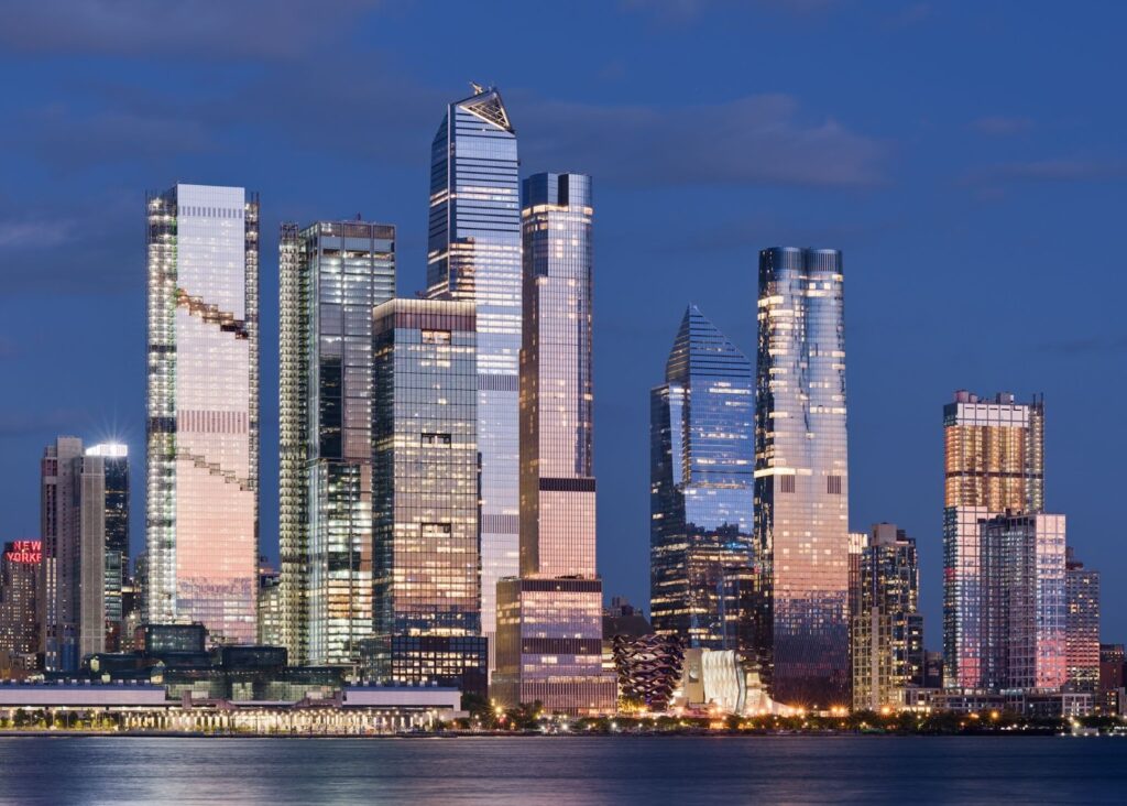 Hudson Yards skyline in Manhattan, New York City, featuring modern glass skyscrapers and high rise towers along the Hudson River waterfront at dusk.