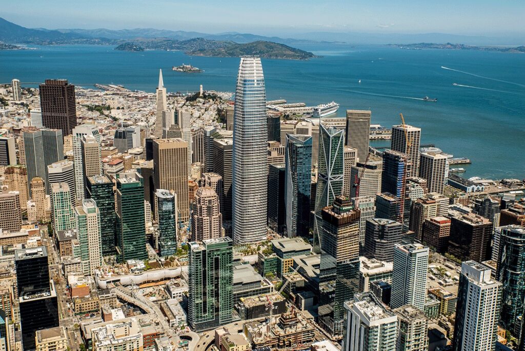 Salesforce Tower dominating the San Francisco skyline, surrounded by modern office buildings near San Francisco Bay and the downtown financial district.