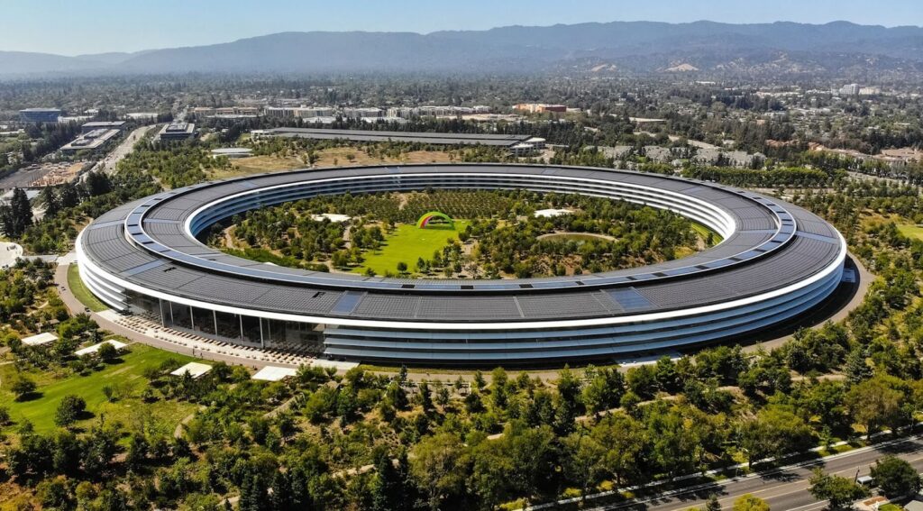 Aerial view of Apple Park headquarters in Cupertino, California, showing the circular ring shaped office building surrounding a large landscaped central park.